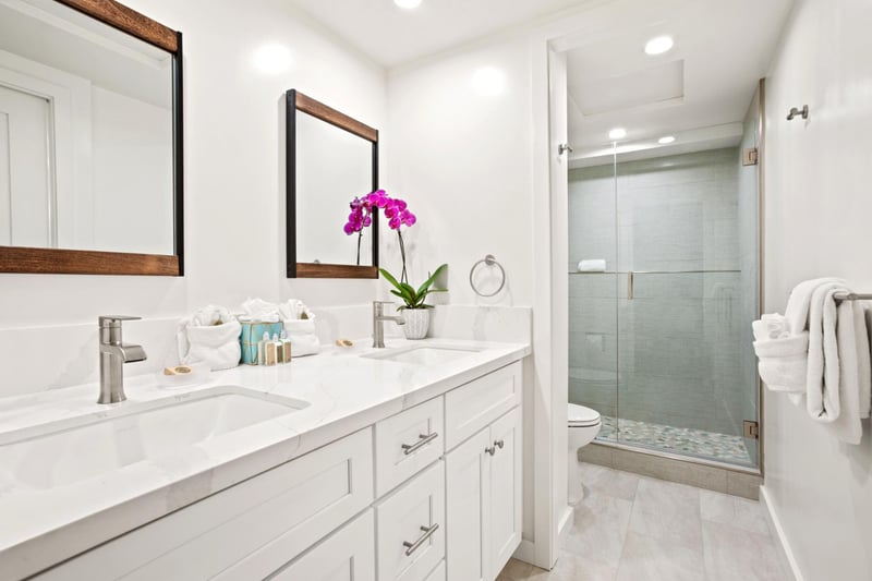 Framed mirrors, artisanal tile, and soft lighting create an organic, upscale spa experience