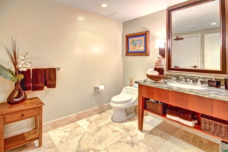 Guest bathroom with granite vanity, full mirror, and warm décor—stylish comfort for a luxurious island stay 
