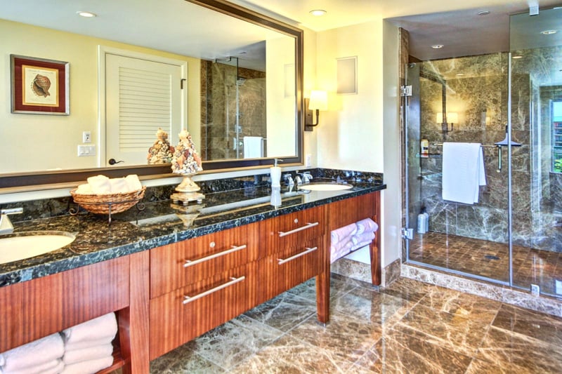 Elegant en-suite with marble flooring, dual vanities, glass shower, and upscale finishes for total indulgence