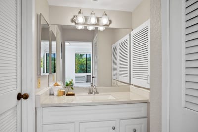 Louvered doors, clean lines, and a bright double vanity make getting ready here feel like a serene daily ritual