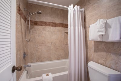 Step behind the curtain into a soothing tiled shower, then towel off and enjoy the bright, polished double vanity