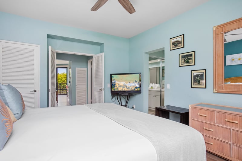 Serene bedroom with ceiling fan and flat-screen TV for a restful stay