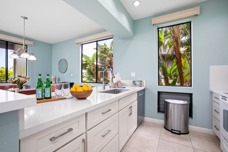 Airy kitchen and dining layout with large windows and tropical ambiance