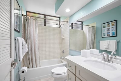 The guest bath features a shower tub combo and classic white finishes