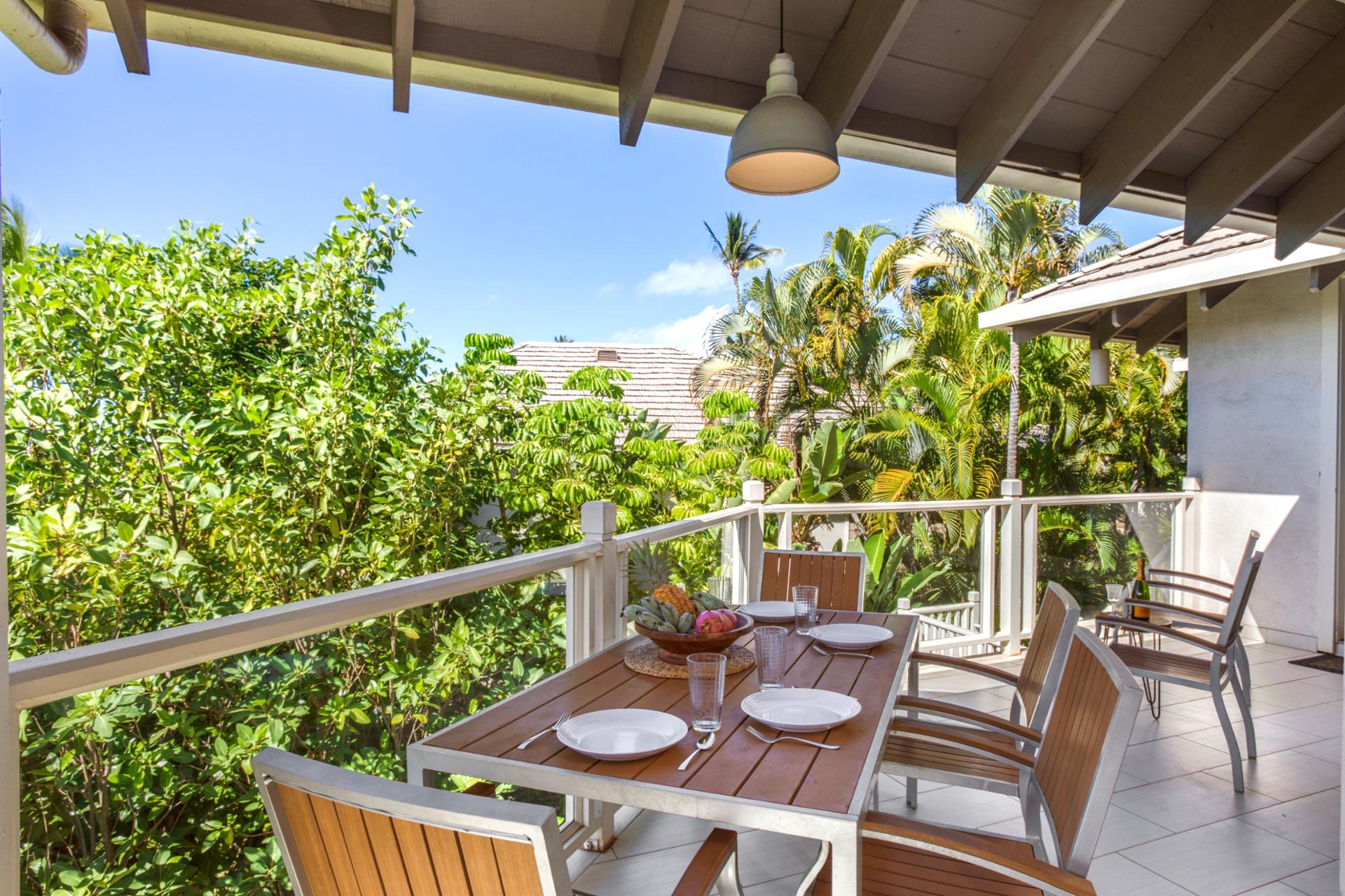 A spacious wrap-around lanai presents lush garden views and ample seating for outdoor relaxation