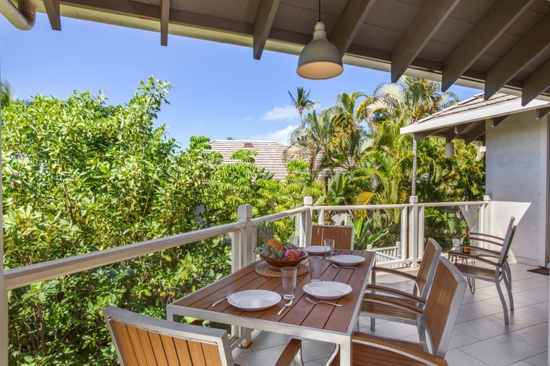 A spacious wrap-around lanai presents lush garden views and ample seating for outdoor relaxation