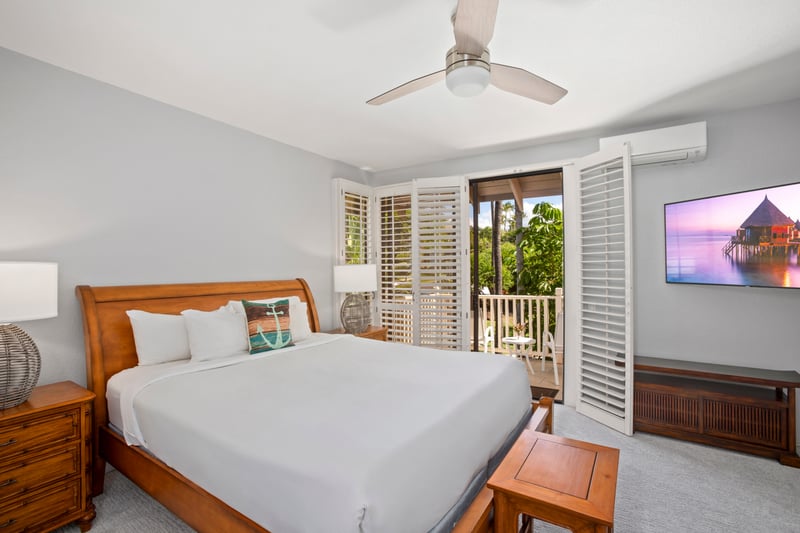 The master suite features a king-sized bed and private access to the lanai for serene mornings