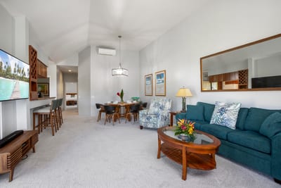 An airy, open-concept living room with plush seating and tropical decor invites relaxation