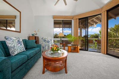 An airy, open-concept living room with plush seating and tropical decor invites relaxation