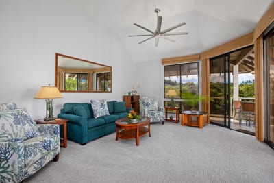 A bright and inviting living room with large windows and tropical accents welcomes you to paradise