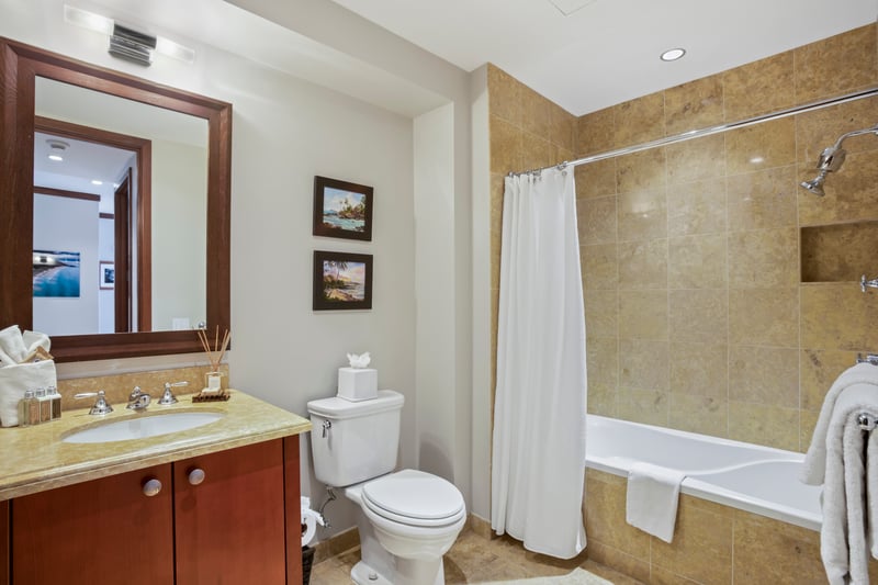 A classic shower curtain keeps it casual, but the gleam of polished fixtures adds a wink of spa-level sophistication