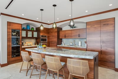 This kitchen wears rich wood grain like a custom-tailored tuxedo—sharp, sleek, and ready to impress your omelet