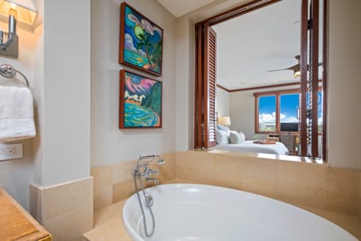Soak beneath vibrant island paintings while sneaking dreamy glances at palm trees and blue skies through wooden shutters