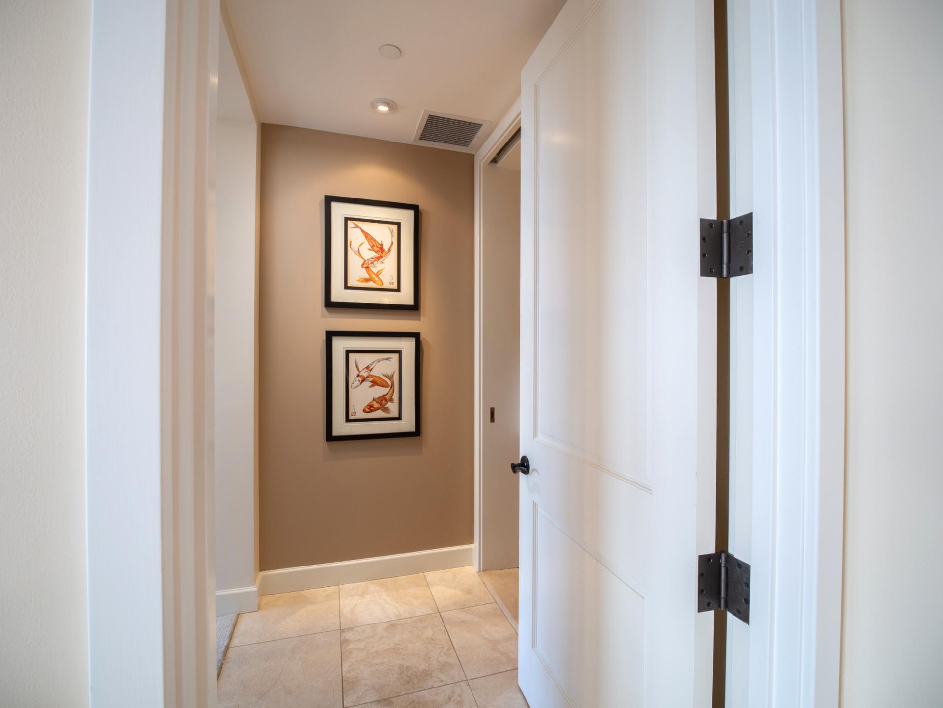 Entry to your suite includes a private hall with framed artwork and bright light.