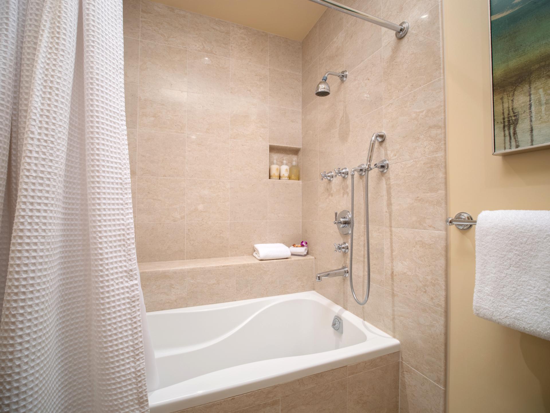 A full tub and handheld shower head offer comfort and flexibility in this guest en suite.
