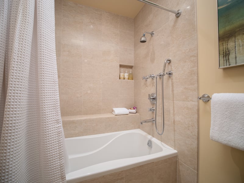 A full tub and handheld shower head offer comfort and flexibility in this guest en suite.