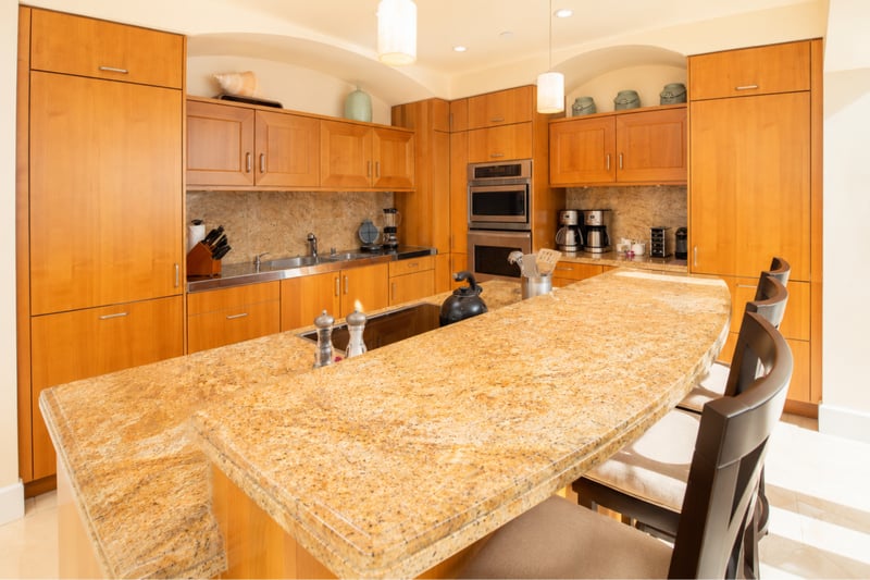 Chef's kitchen at Wailea Beach Villas PH505 — granite island seating for three beneath pendant lighting WBV-PH505