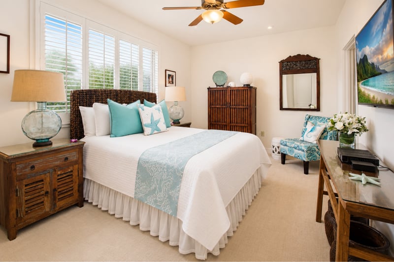 Guest bedroom at Wailea Beach Villas PH505 — woven headboard, teal starfish pillow, and glass table lamps WBV-PH505