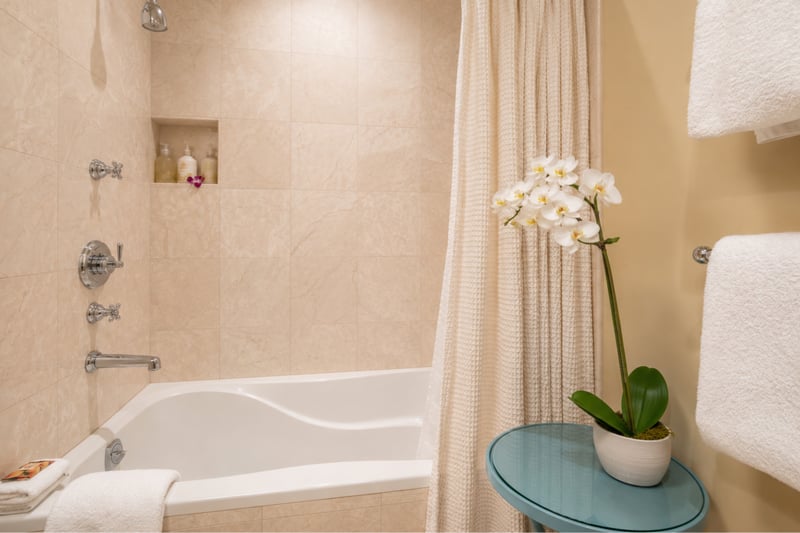 Guest bath detail at Wailea Beach Villas PH505 — fresh orchid accents beside the tub-shower combo WBV-PH505