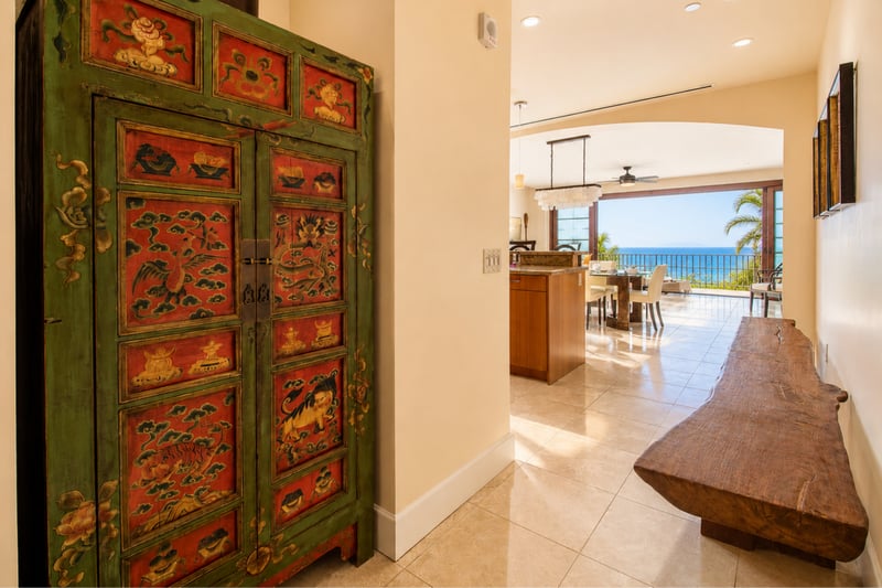 Entry hall at Wailea Beach Villas PH505 — hand-painted antique Chinese cabinet with an open sightline to the kitchen and ocean beyond WBV-PH505