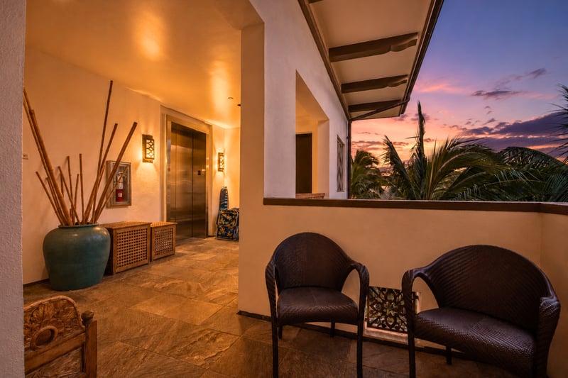 Private elevator lobby at Wailea Beach Villas PH505 — outdoor seating and a sunset view over the palms WBV-PH505