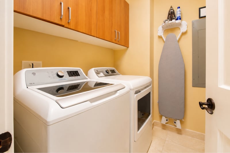 In-unit laundry at Wailea Beach Villas PH505 — full-size GE washer and dryer with a wall-mounted ironing station WBV-PH505