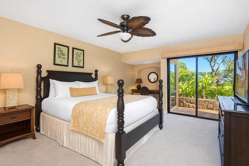 This king-sized bed is tall, elegant, and ready to cradle you in royal comfort with breezes sneaking in through the glass
