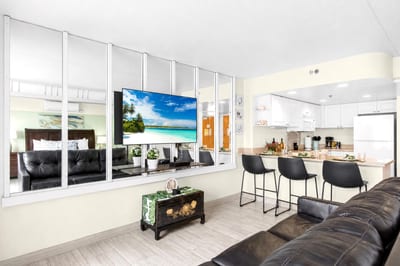 Comfortable living room with large smart TV, modern furnishings, and an inviting space to unwind after a day in Waikiki