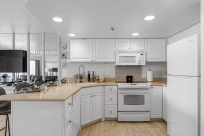 Bright open kitchen featuring full-size appliances, generous storage, and convenient breakfast bar seating