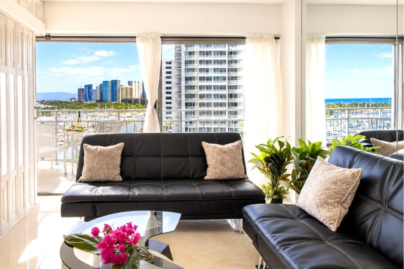 Sink into sleek leather sofas framed by floor-to-ceiling windows - marina, skyline, and a sliver of ocean as your backdrop.