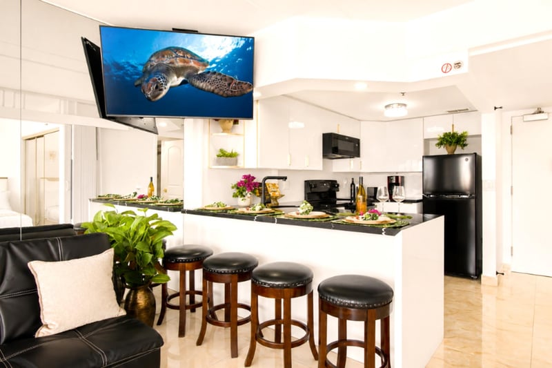 Gather at the black-granite breakfast bar for four, steps from a fully equipped modern kitchen - casual island dinners with a Smart TV in view.