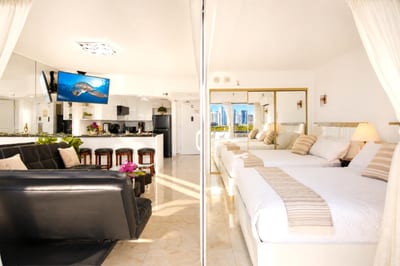 The full open-plan layout at a glance - leather lounge, breakfast bar, and two queen beds flowing out to the lanai and Waikiki views beyond.