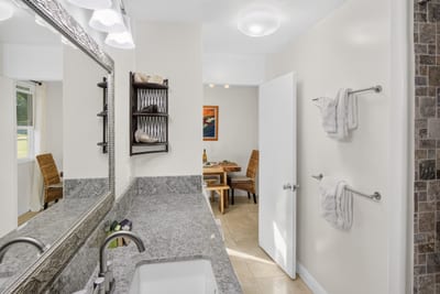 The spacious bathroom features ample counter space and several towel racks for convenience