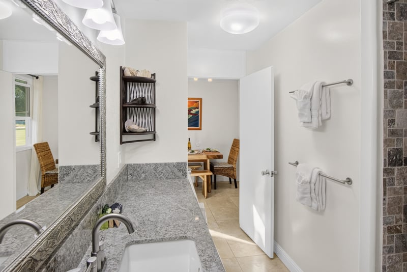 The spacious bathroom features ample counter space and several towel racks for convenience