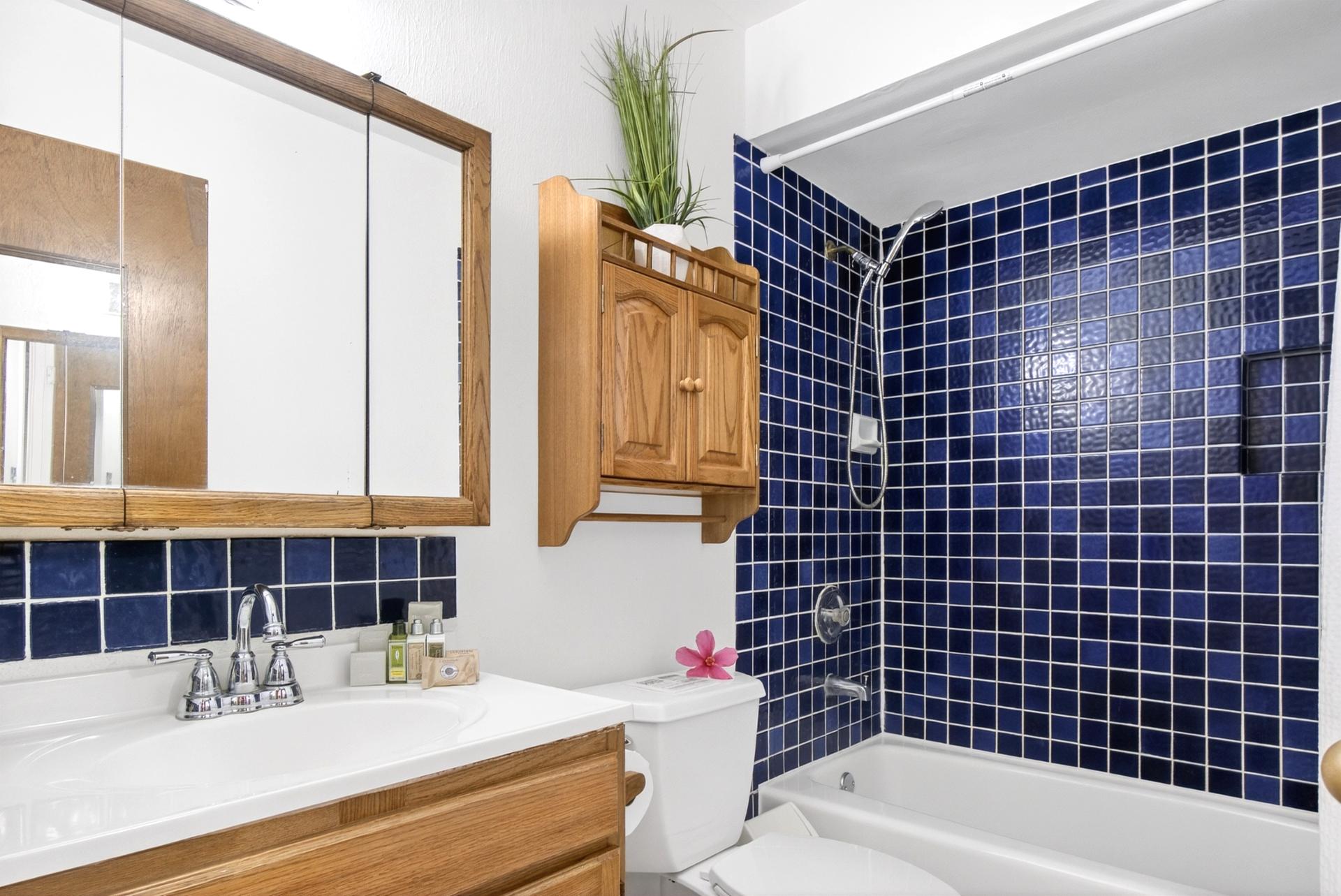 Step into a cozy retreat where rich navy tiles and warm wood finishes meet in a perfect splash of retro hospitality    