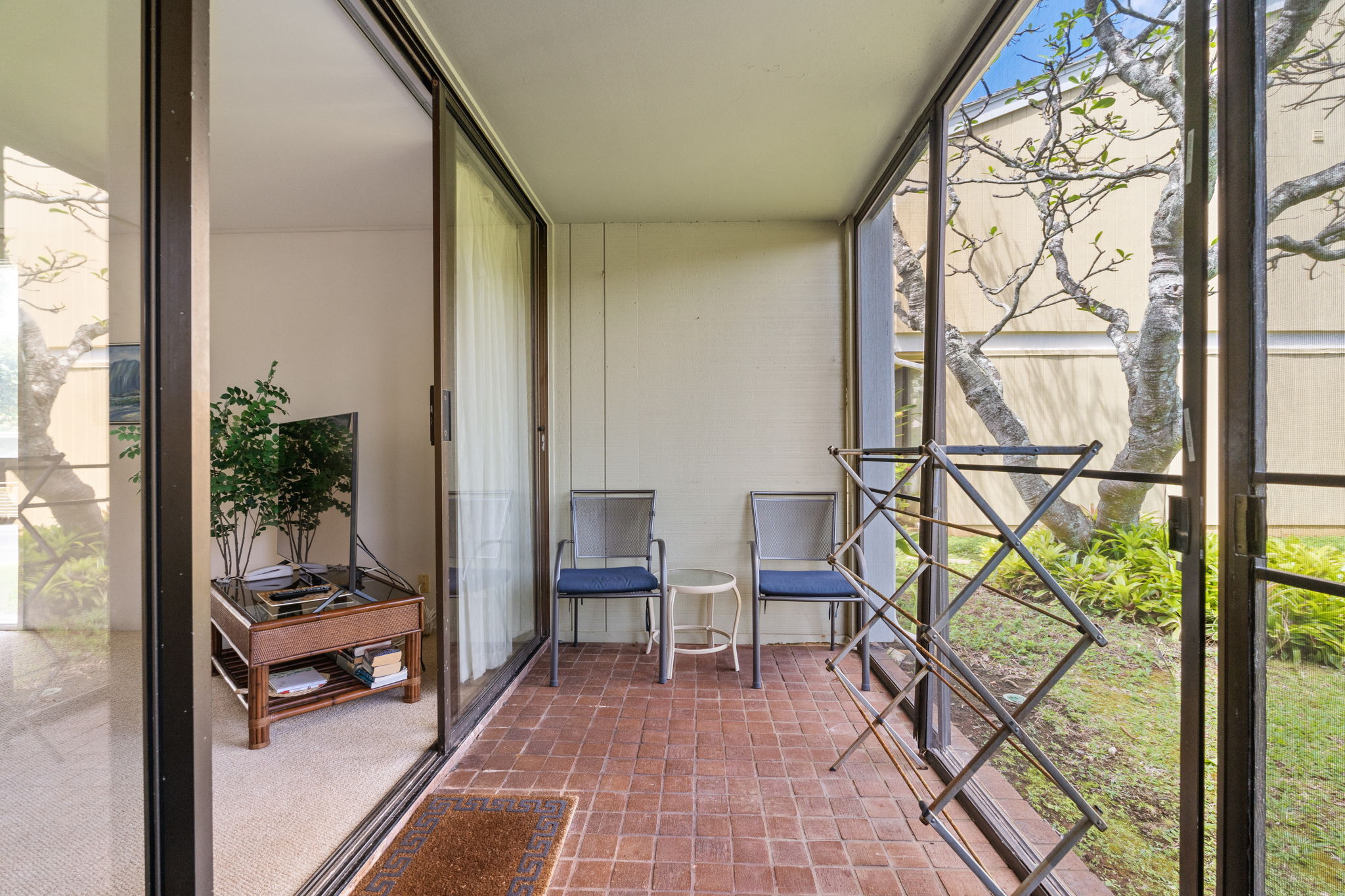 This screened lanai offers the perfect perch to sip, sway, and spy on butterflies flitting through the garden    
