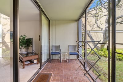 This screened lanai offers the perfect perch to sip, sway, and spy on butterflies flitting through the garden