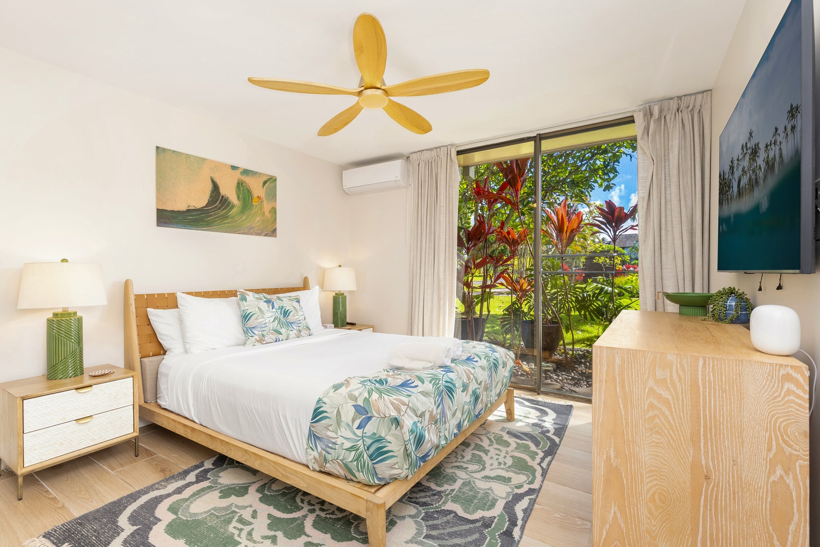 The bedroom on the main floor of this condo has floor-to-ceiling glass sliders and a Queen-size bed. 