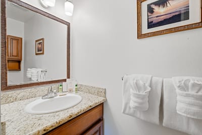 Granite counters, soft lighting, and a wide vanity with L’Occitane amenities.