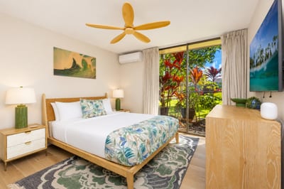 The bedroom on the main floor of this condo has floor-to-ceiling glass sliders and a Queen-size bed.