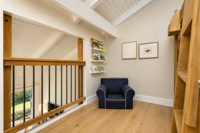 Tucked away in the corner of the upstairs loft, this cozy nook includes the perfect reading spot for quiet space to relax.