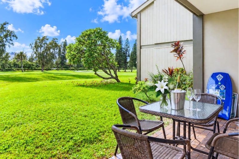 Private lanai at Kuilima West Estates 144, with wicker seating and an open golf course view just steps from the living room.
