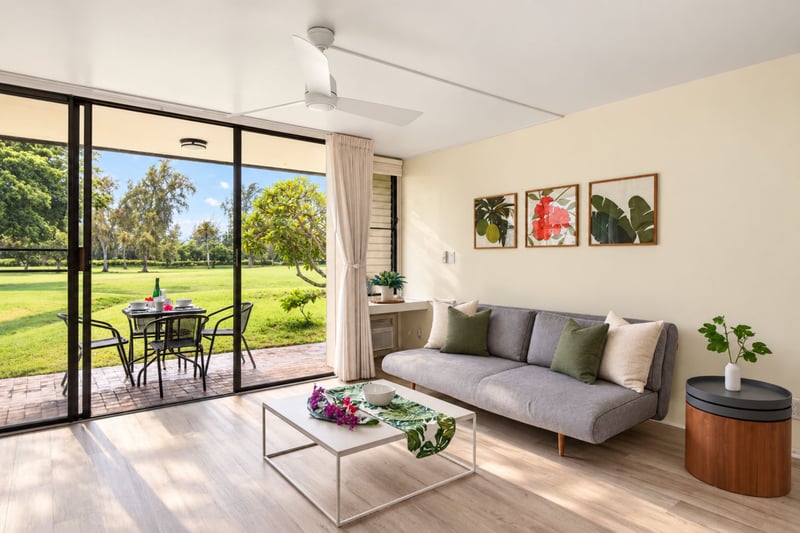 Living room at Kuilima West Estates 144, with golf course views through the sliding glass door and comfortable seating for the whole group.