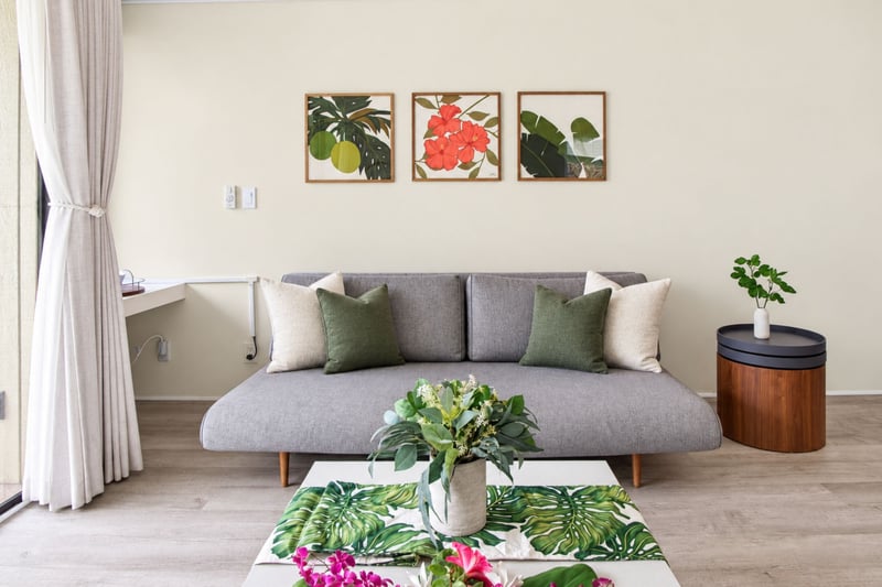 Living room detail at Kuilima West Estates 144, with tropical botanical art and plush sofa styling.