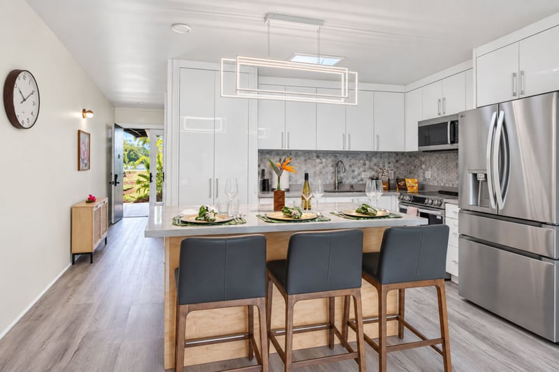 Kitchen island seating at Kuilima West Estates 144, with bar-height seating for three beneath a modern linear light fixture.