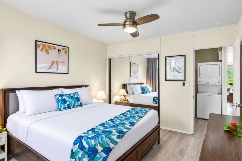 Primary bedroom at Kuilima West Estates 144, with mirrored closet doors and convenient in-unit laundry access across the hall..
