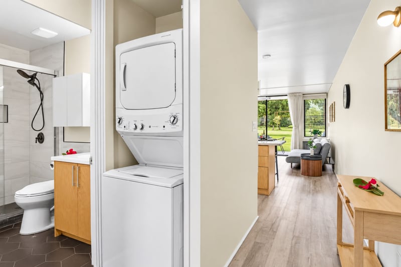 In-unit laundry at Kuilima West Estates 144, with a stacked full-size washer and dryer tucked conveniently off the primary suite.