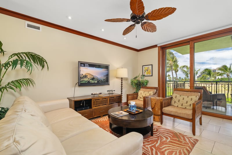 This living room feels like a resort retreat—leafy palms indoors and swaying ones just outside your window    