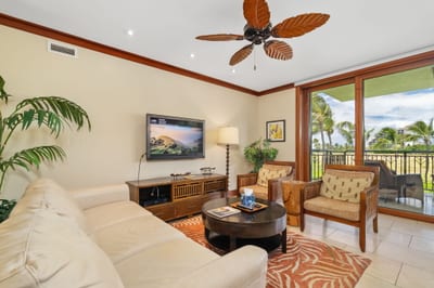 This living room feels like a resort retreat—leafy palms indoors and swaying ones just outside your window
