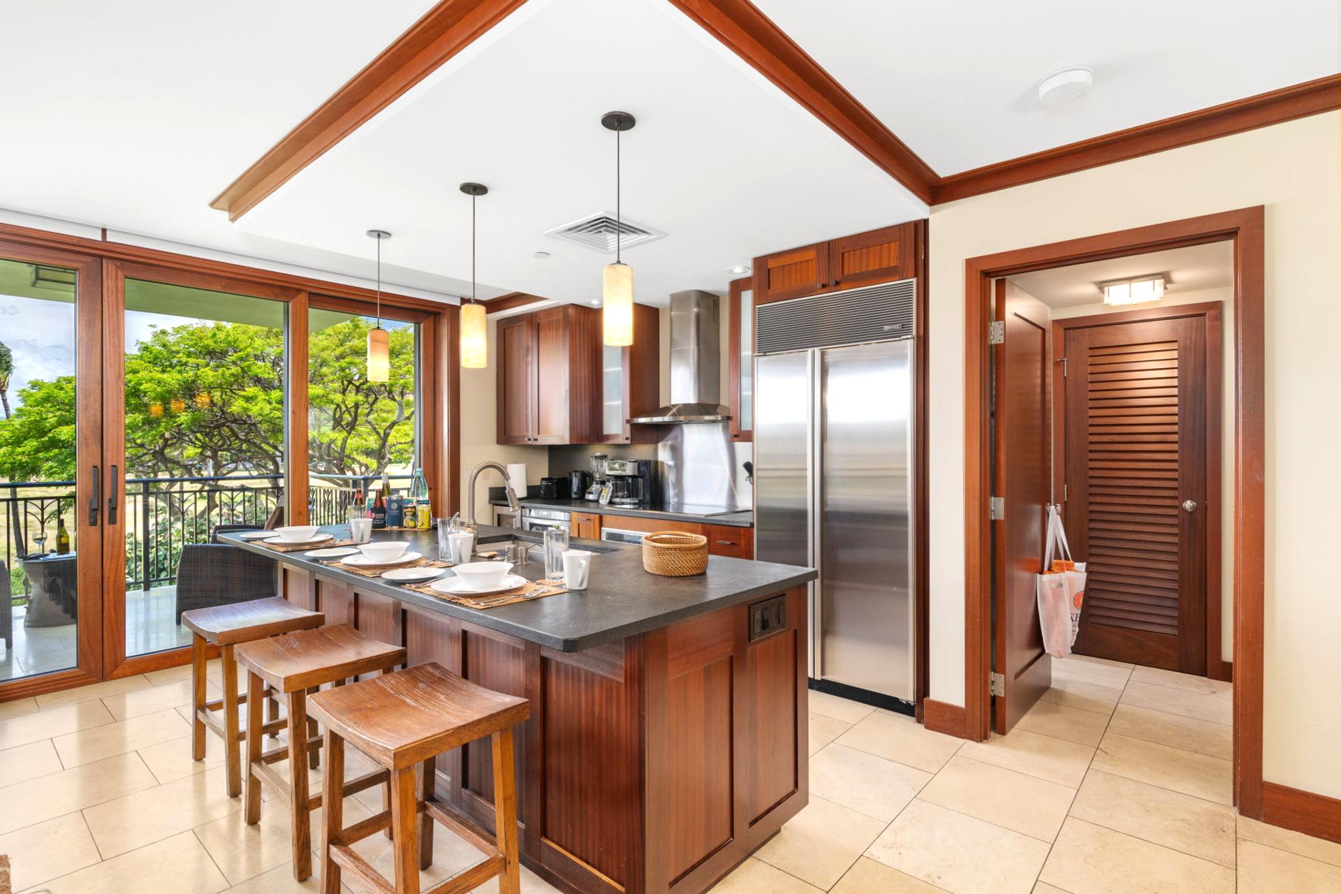 Tropical trees sway just beyond your prep space in this open-layout kitchen, designed for both ease and escape    
